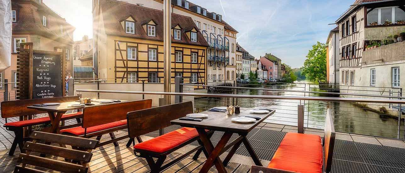 Eckerts Wirtshaus Brückenterrasse im Sonnenschein mit Blick über die Regnitz in den Hain